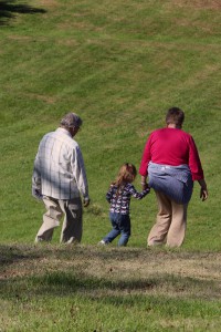 grandparents holding hands with child walking away